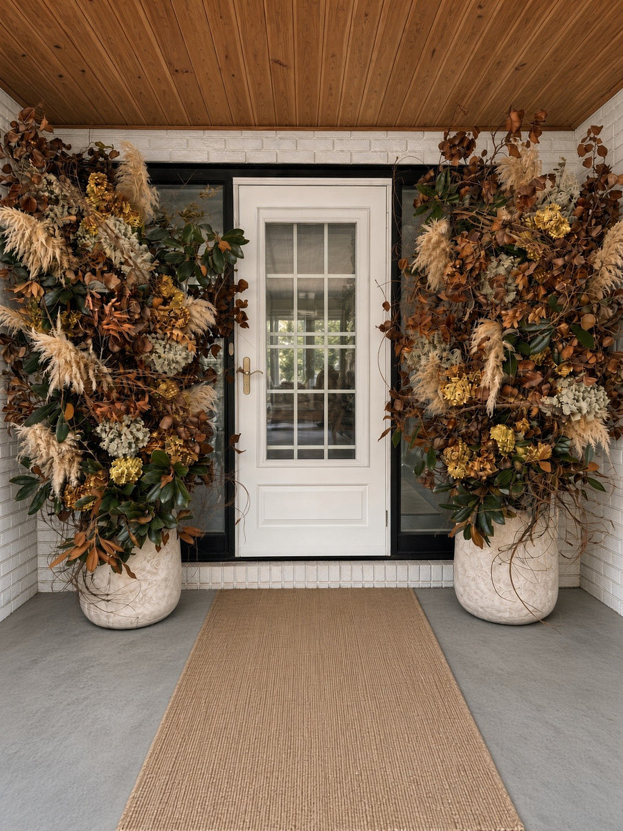 Elegant Entryway: tall dried arrangements in stone planters framing a white front door