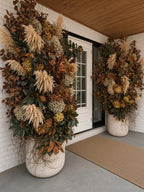 Elegant Entryway up close: pampas, hydrangea, and magnolia rising from a stone planter